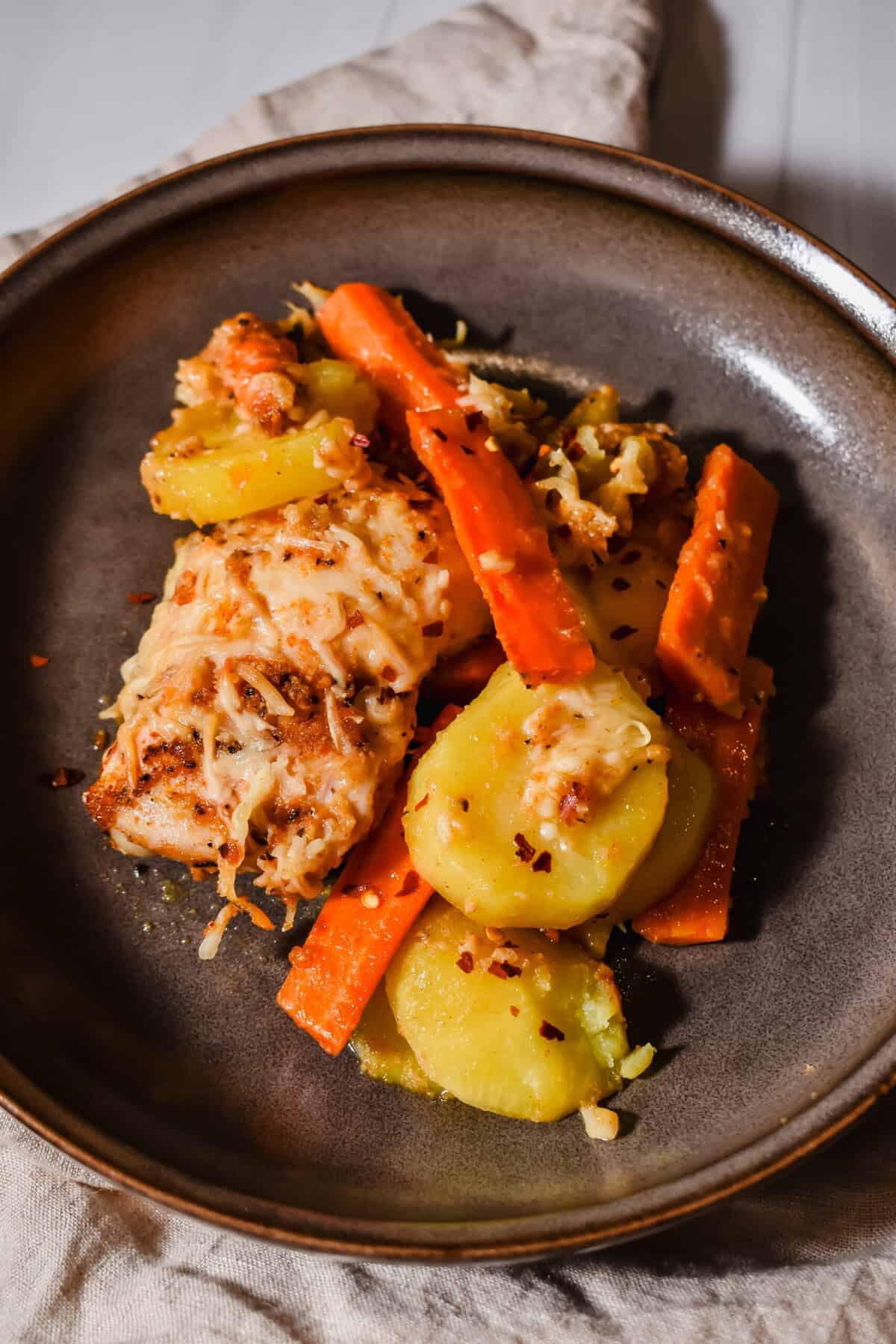 This is a close up of a serving of my garlic parmesan chicken and potatoes in a plate.