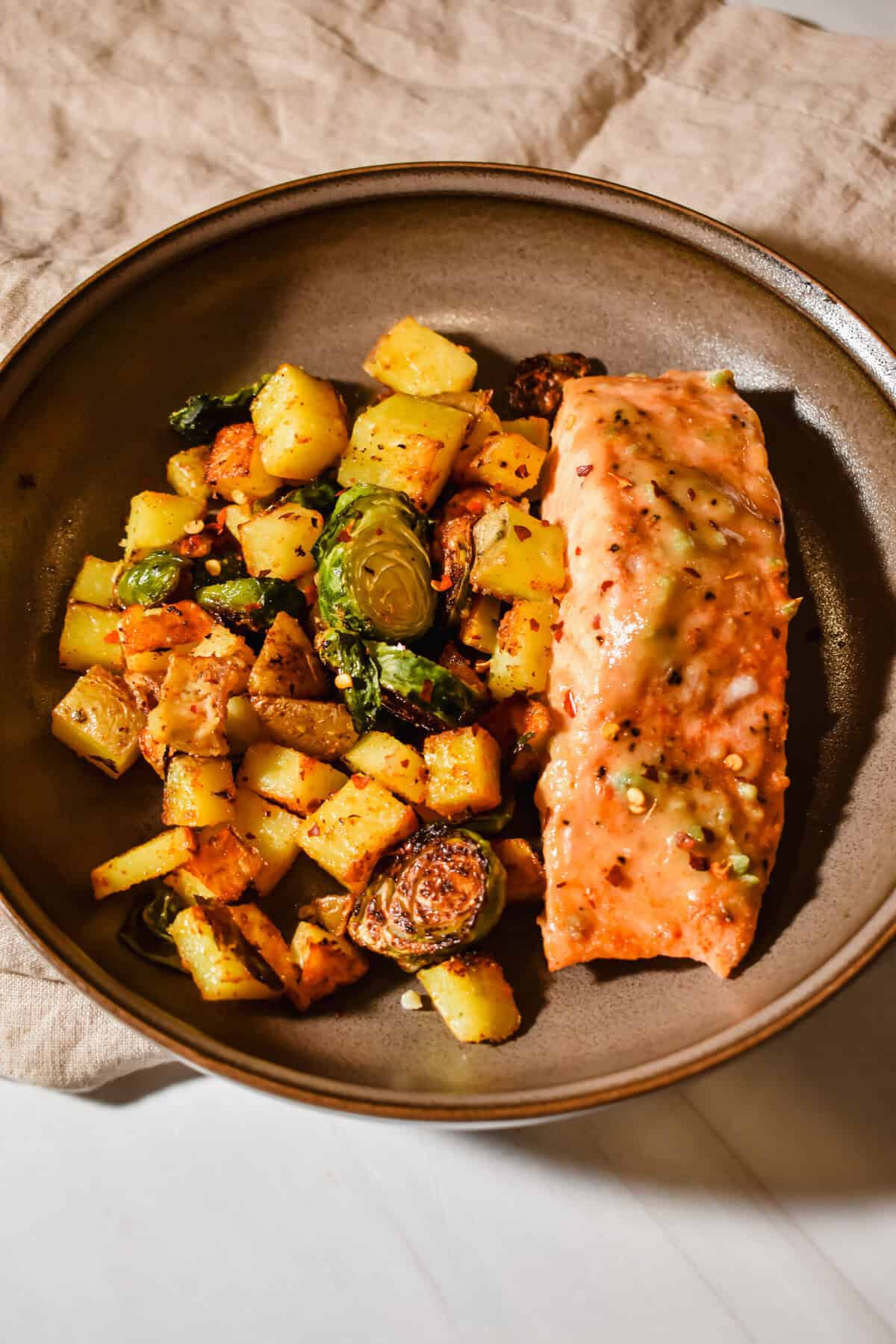 this is a top view close up of my maple dijon salmon with roasted potatoes and brussels sprouts 