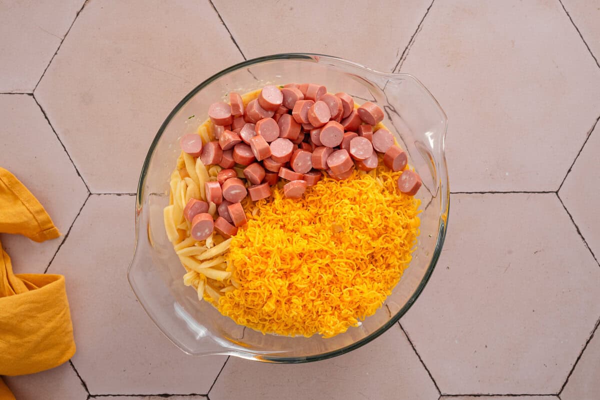 shows the hashbrowns, sliced sausage and cheese in a bowl 