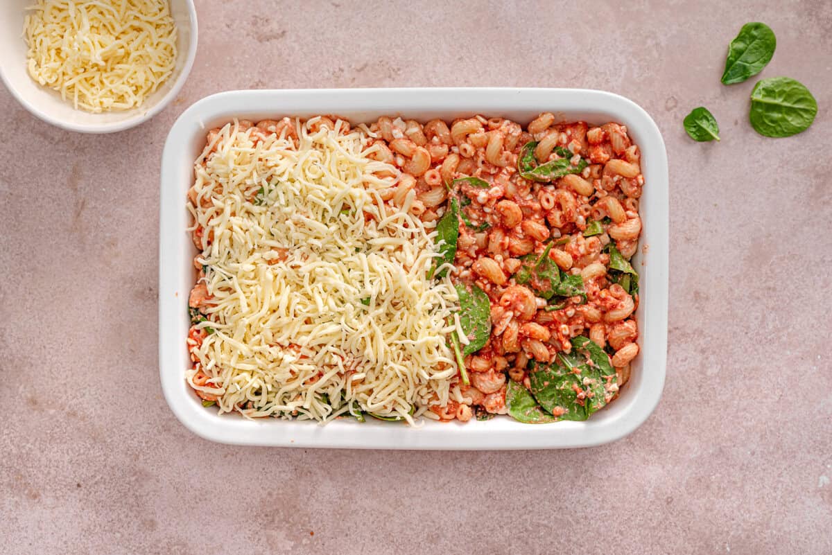 this shows the pasta mixed together in the pan with the marinara and other ingredients. Then it shows me topping it with cheese.