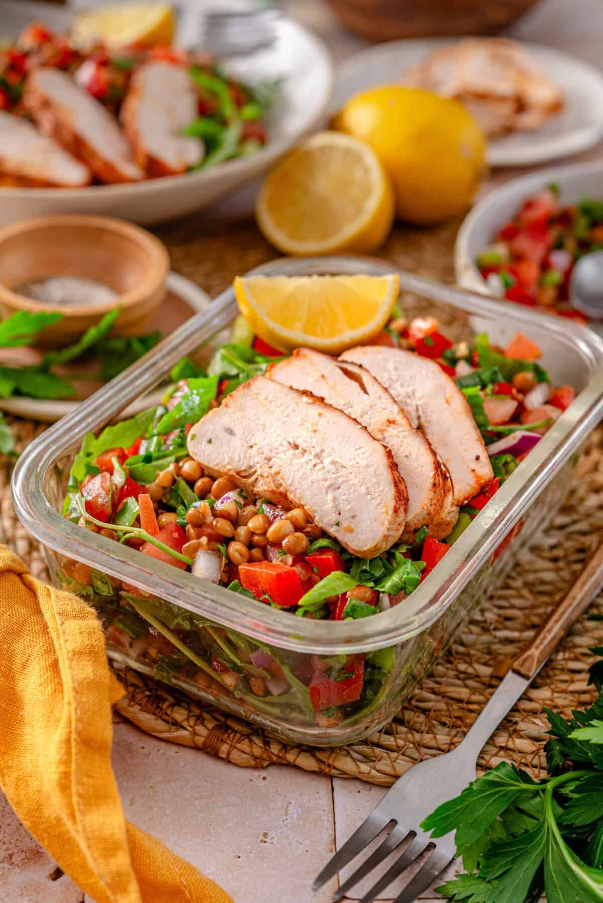 this is a side view close up of my Lentil Tabouli Salad (Meal Prep Friendly) in a glass meal prep bowl 
