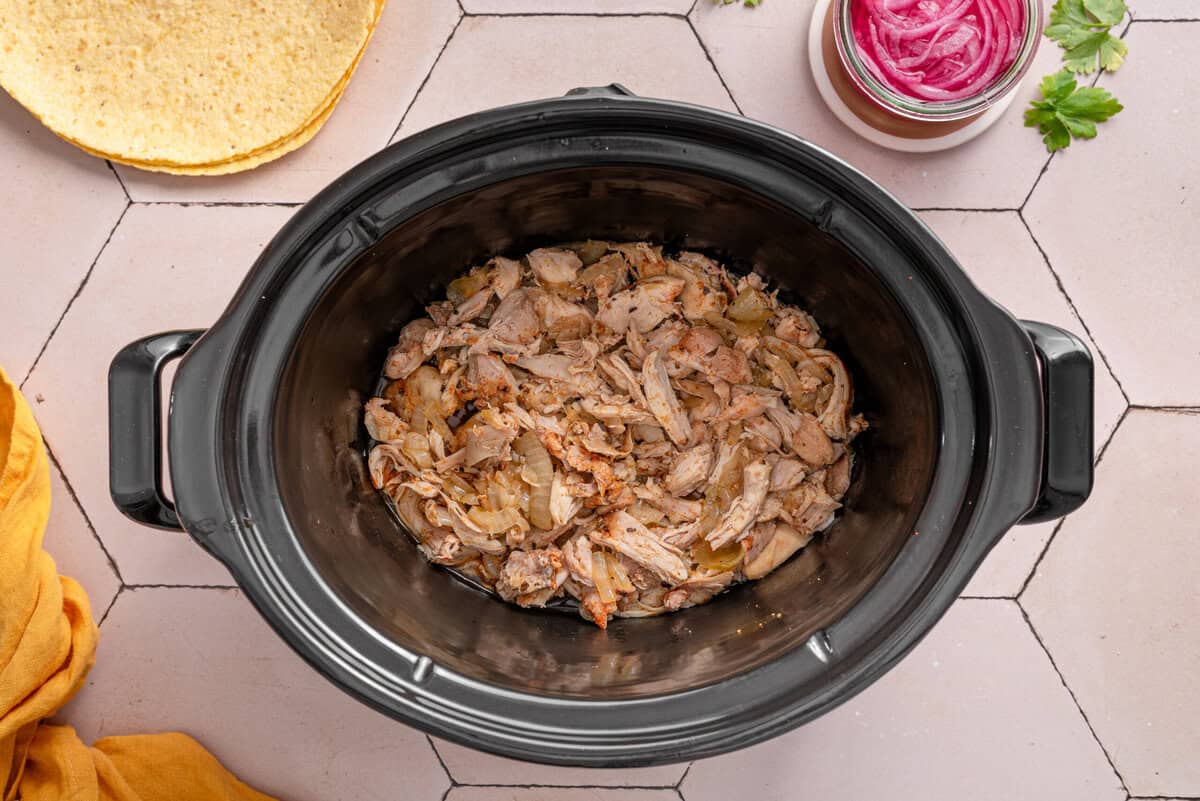 Overhead shot of shredded chicken in crockpot.