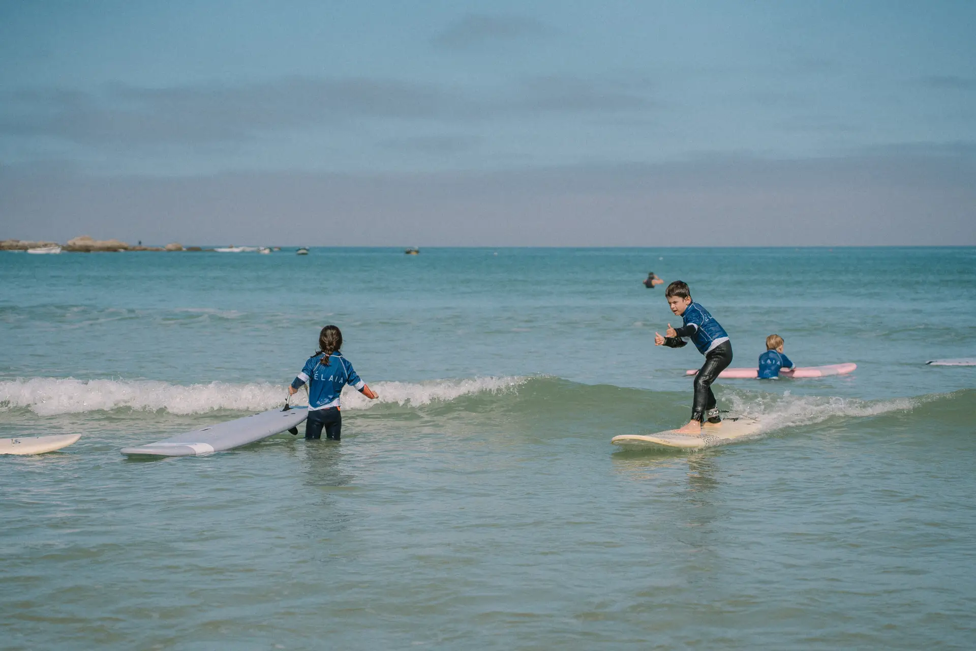 Un enfant surfe une vague à la Torche