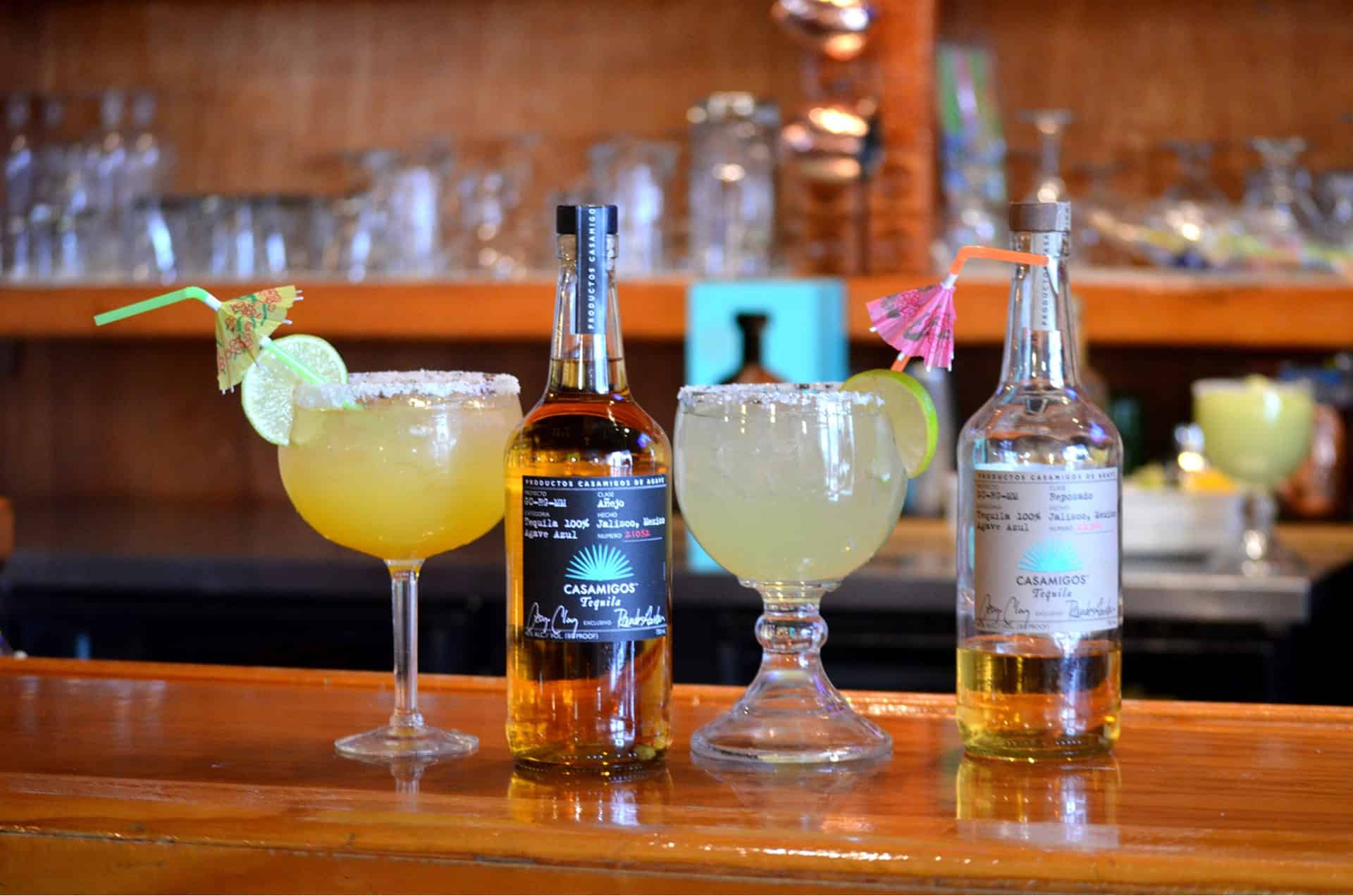 Refreshing margaritas with lime and salt, served with tequila bottles at El Burrito Loco, Muskegon.