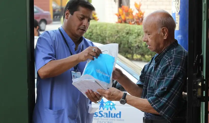 Foto reciente de una persona mayor recibiendo medicamentos en su domicilio, con logo de EsSalud visible.