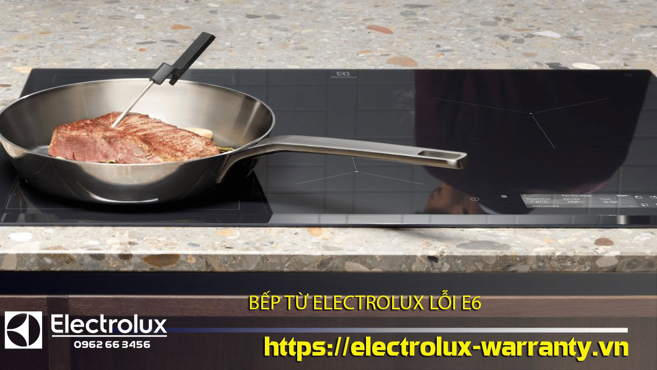 Stainless steel wok pan on a modern black Electrolux induction cooktop demonstrating Electrolux warranty service.