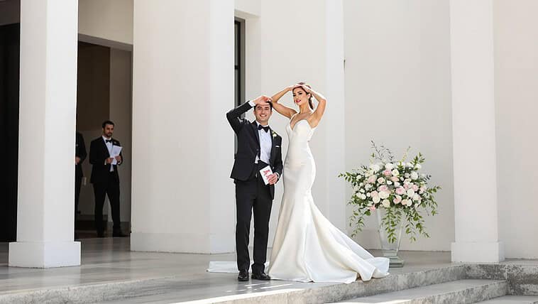 Elegant wedding couple standing outside a modern building.