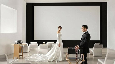 Bride and groom exchanging vows in a modern wedding venue with minimal decor.