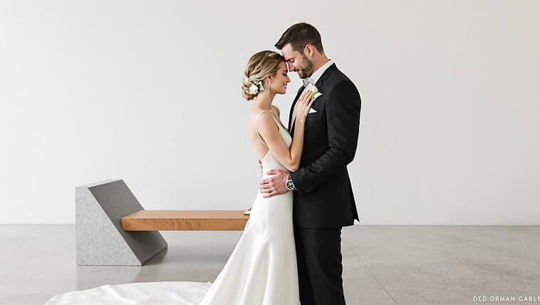 Elegant wedding couple embracing in minimalist setting, celebrating love and commitment.