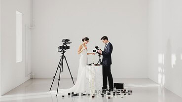 Bride and groom filming wedding scene with professional camera equipment.