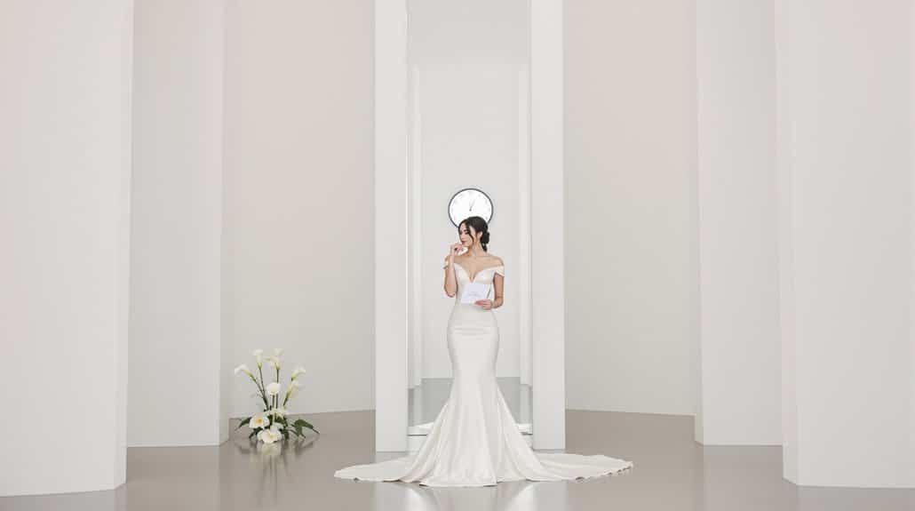 Bride in elegant white wedding gown in minimalist setting.