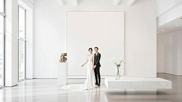 Bride and groom standing together in a sleek, modern wedding venue with minimalist decor.