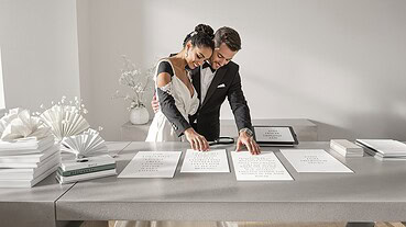 Elegant wedding couple signing marriage documents at a modern venue.