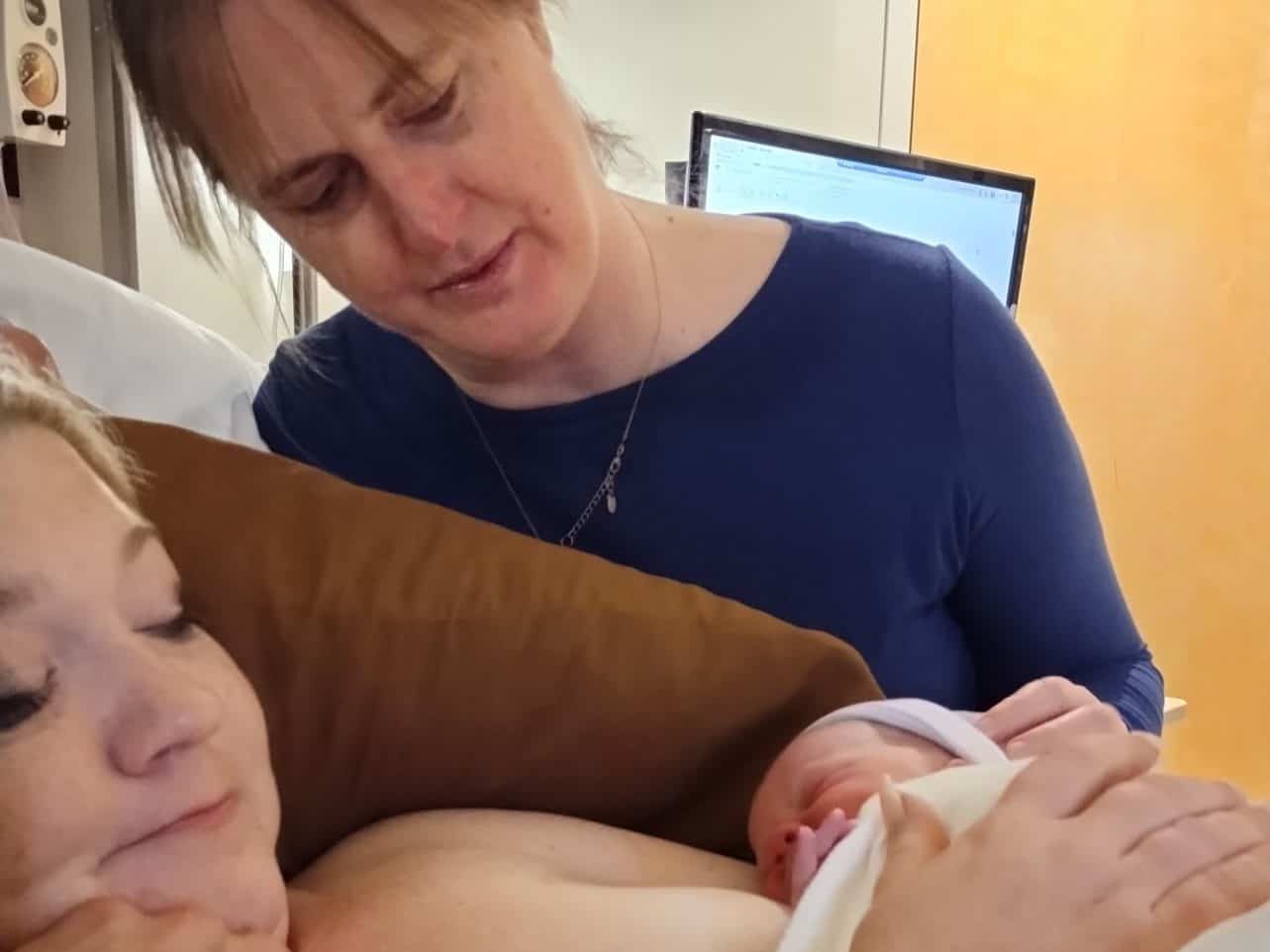 Rachel Bailey, birth doula and postpartum doula, helps a mom greet her newborn baby in Anniston, Alabama.