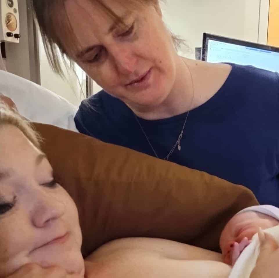 Rachel Bailey, birth doula and postpartum doula, helps a mom greet her newborn baby in Anniston, Alabama.