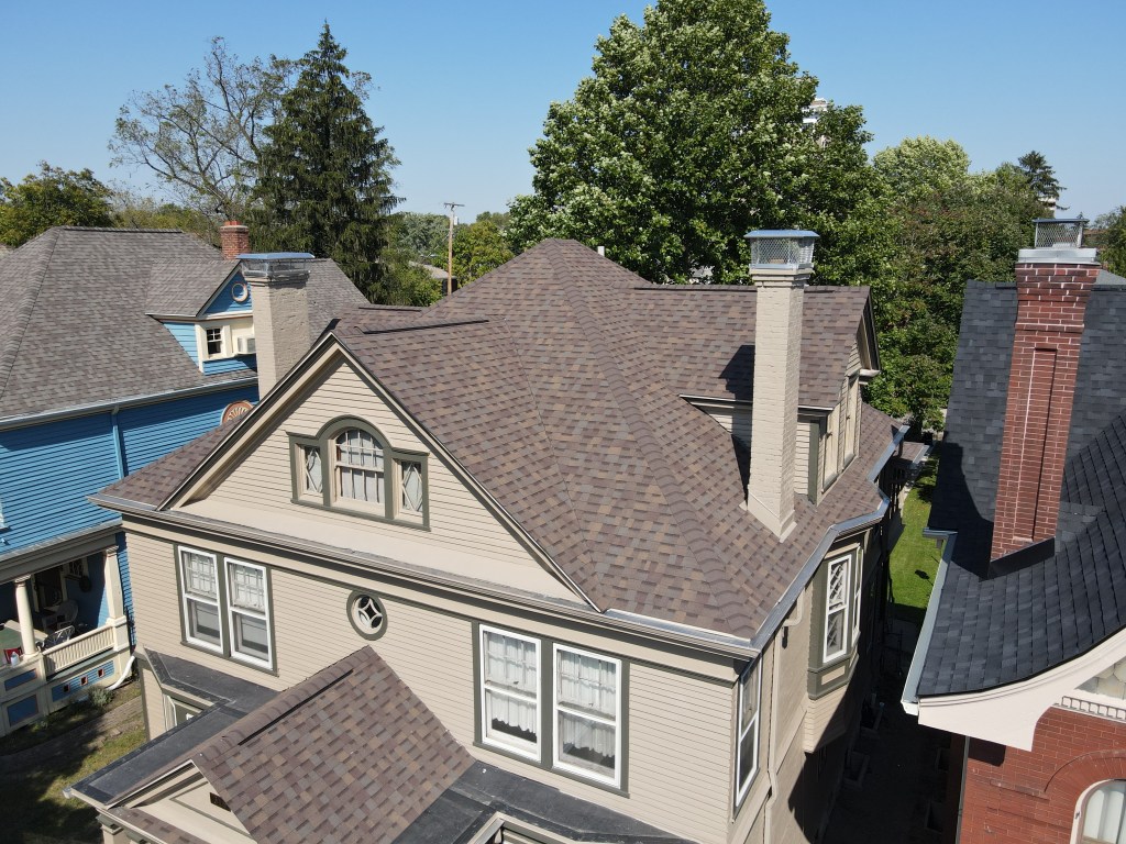 Aerial view of a residential roof with new asphalt shingles, focusing on roofing installation and home exterior renovation by Elevated Roofing and Siding.