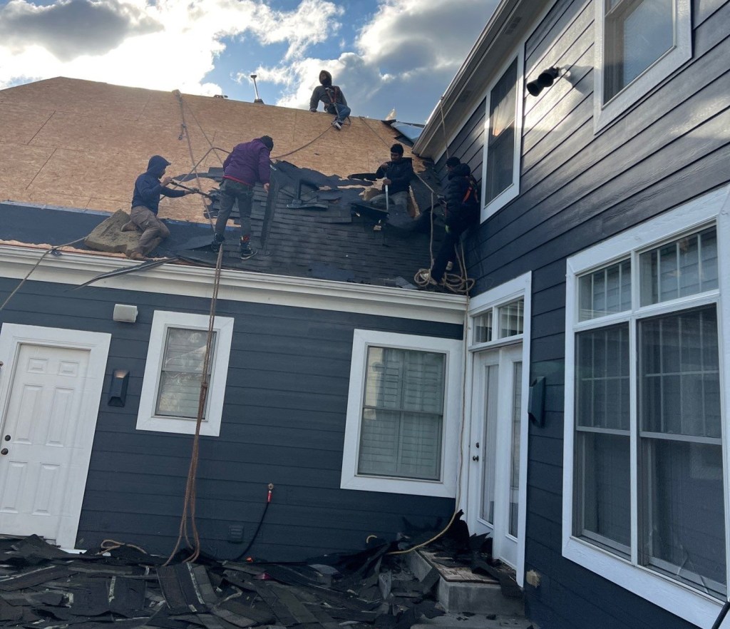 High-quality residential roof replacement with professional roofing team installing durable shingles.