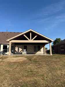 Modern house with durable roofing and siding, featuring an attractive covered patio, showcasing home exterior renovation, quality roofing materials, and siding installation for curb appeal.
