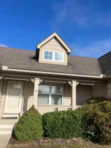 High-quality siding installation on a suburban home with a dormer window, showcasing durable materials and expert craftsmanship.