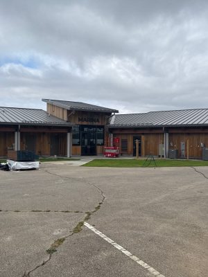 Modern marina building with durable metal roofing and wooden siding featuring exterior renovations, roofing, and siding installation by Elevated Roofing and Siding.