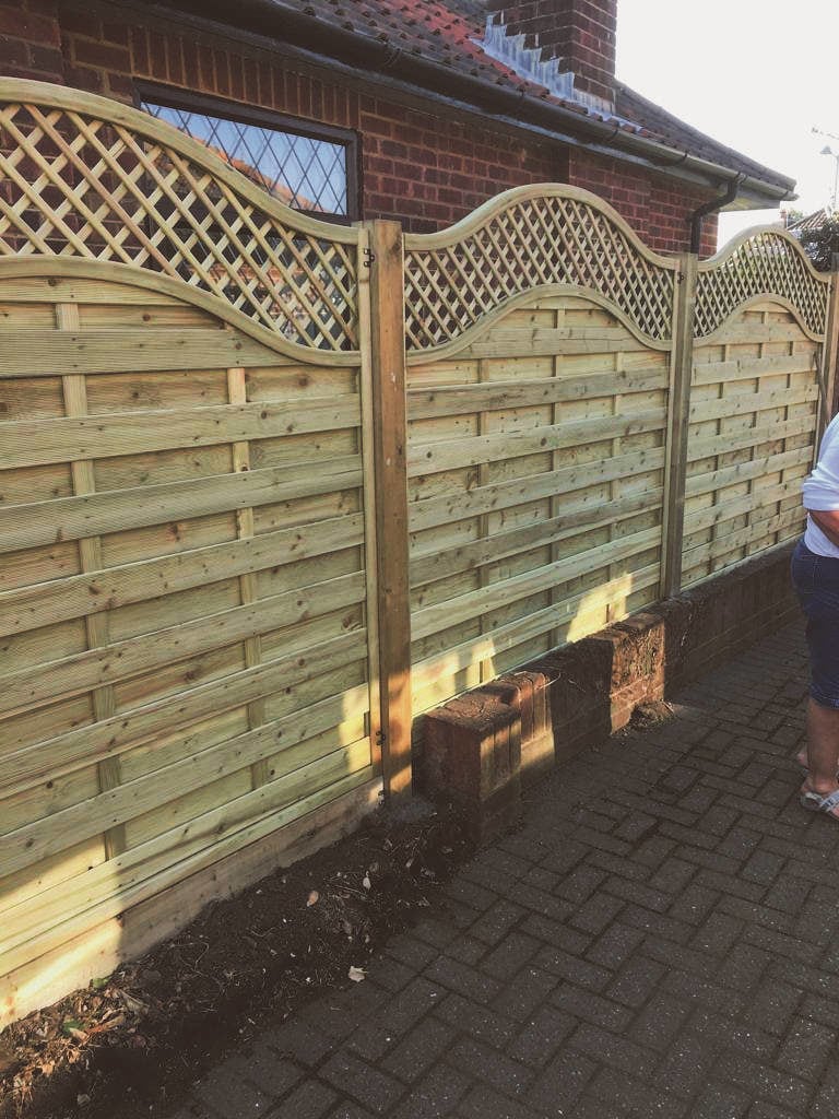 New wooden garden fence with decorative top design for privacy and style.