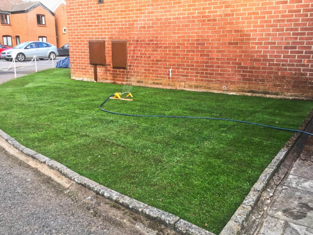 Well-maintained garden lawn with a hose pipe in Suffolk.