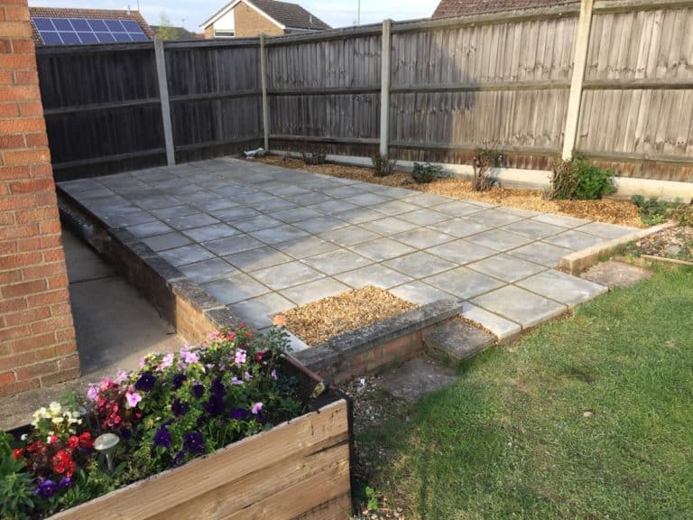 Newly paved patio area with stone tiles and garden border in Suffolk.