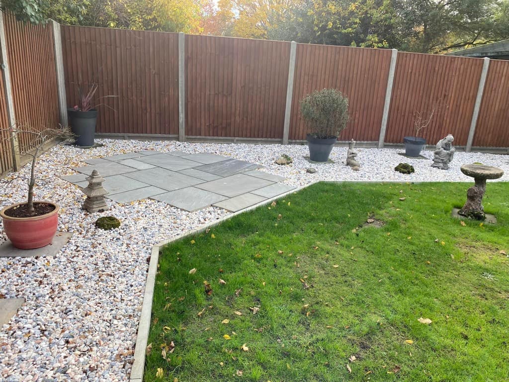 Garden with new fencing, paving, and decorative garden ornaments.