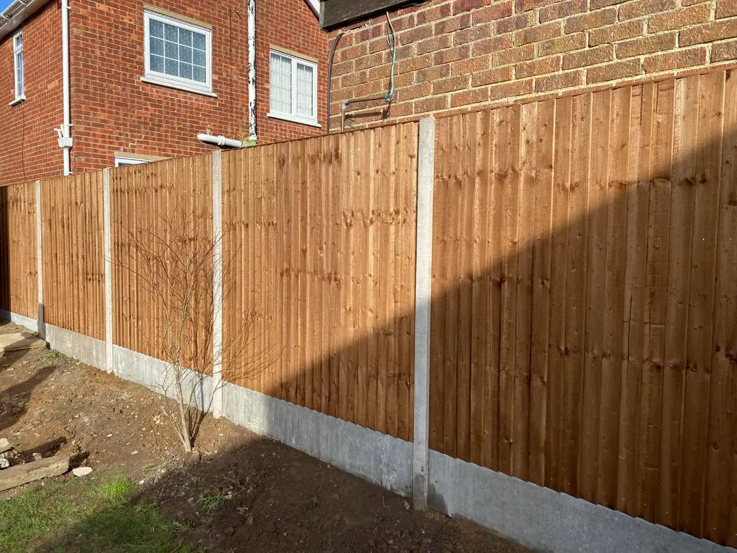 New wooden garden fence with concrete posts and gravel board.