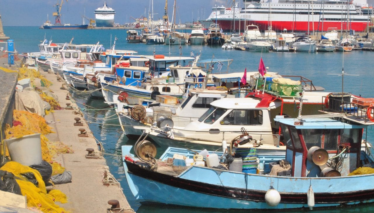 A fishing boat with a cruise ship in the background