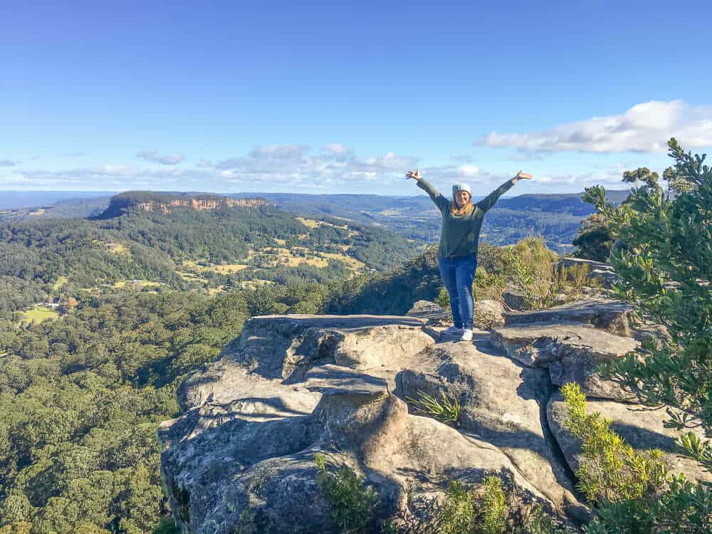 A girl standing on top of a mountain