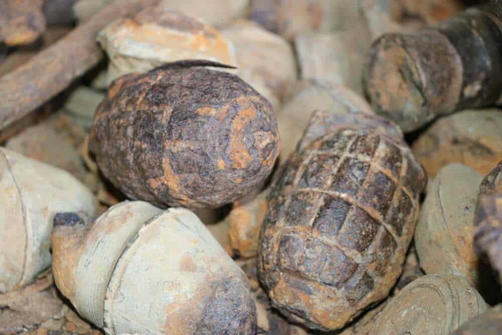 Old rusty artillery shells and projectiles on a collection pile, showcasing vintage military ammunition, likely from wartime, with weathered metal surfaces and distinct patterns, ideal for history enthusiasts and collectors.