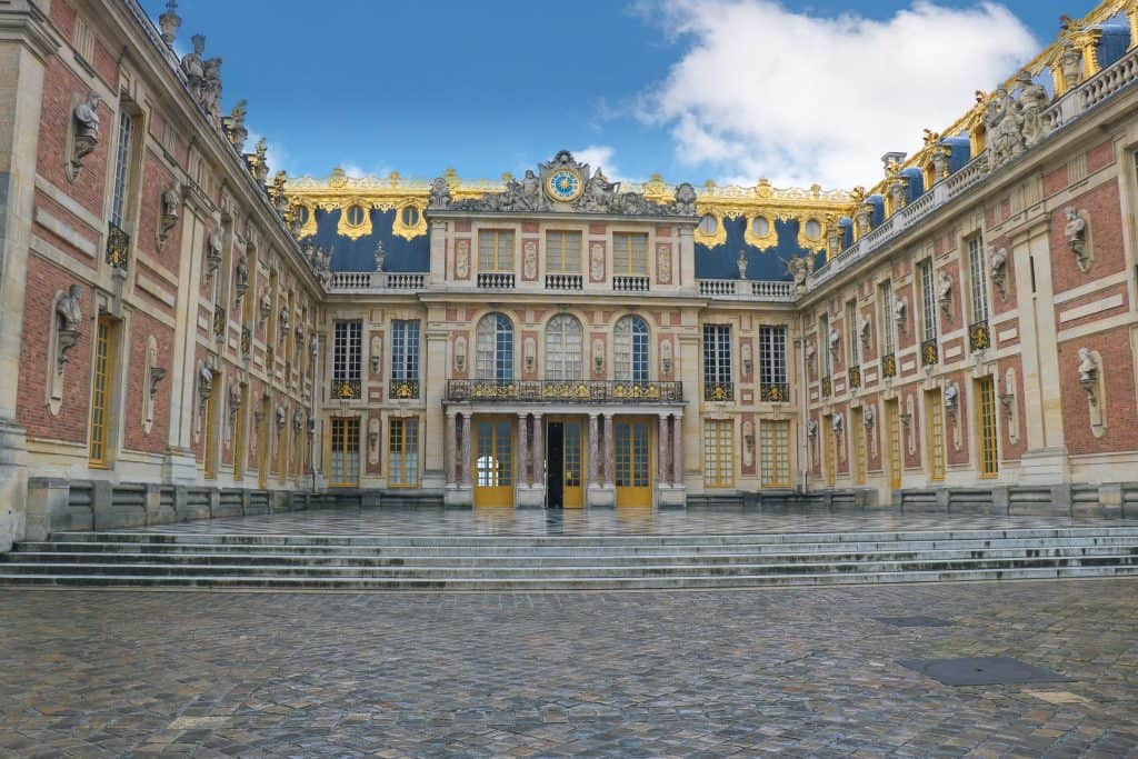 The U-Shaped courtyard of the Palace of Versailles. The top of the palace roof is covered in gold.