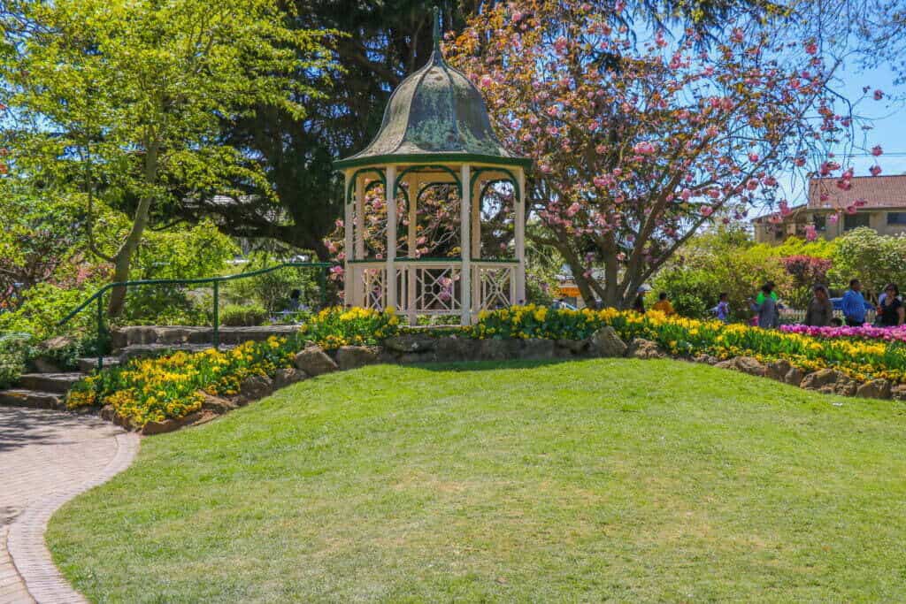 A gazebo in the centre of a lush green lawn in the Corbett Gardens of Bowral