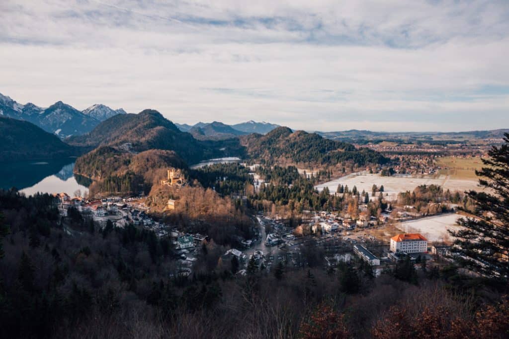 A shadowy view over rolling hills and snowcapped trees