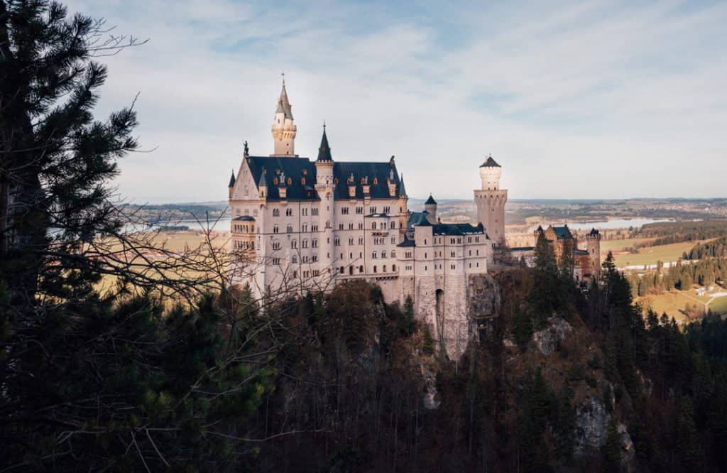 The blue turrets of Neuschwanstein Castle against the blue sky.