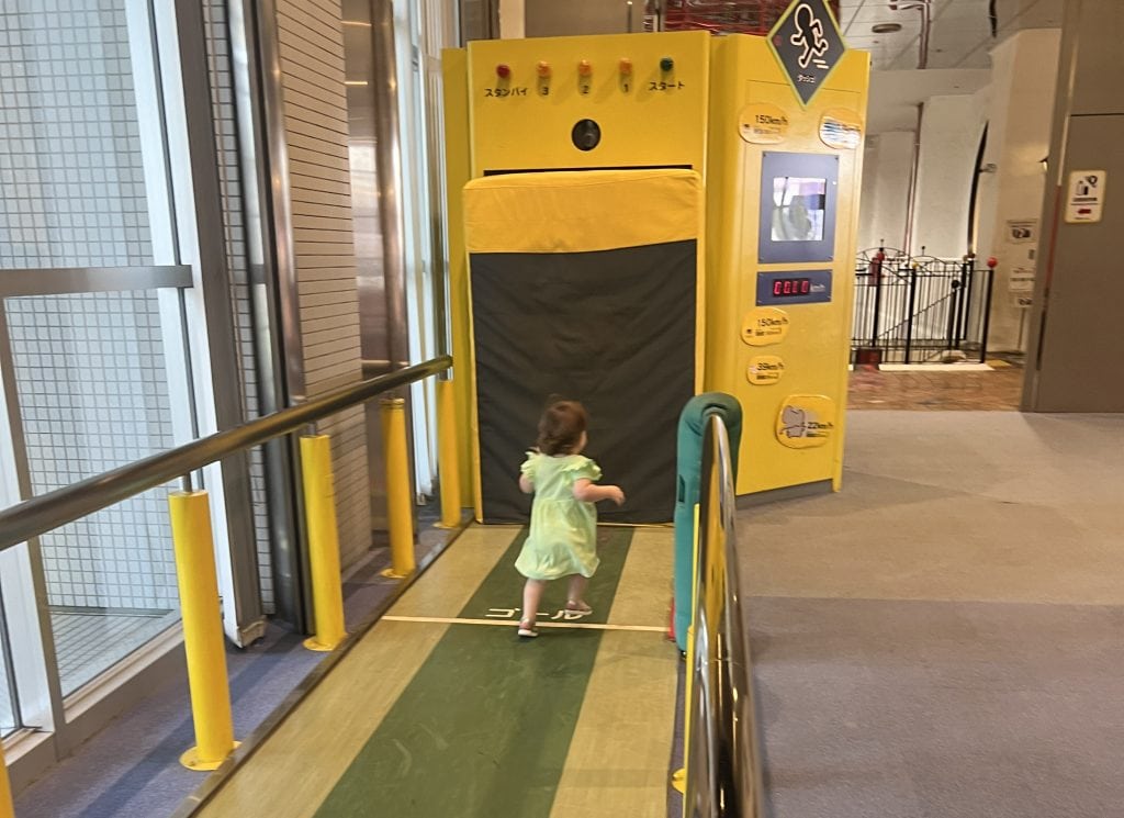 A small girl runs down the sprint track at the Osaka Kids Plaza