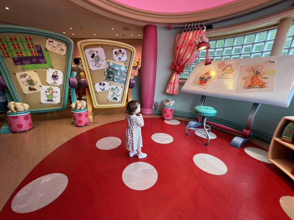 A toddler stands in the middle of a colourful room, Minnie Mouse's studio at Tokyo Disney