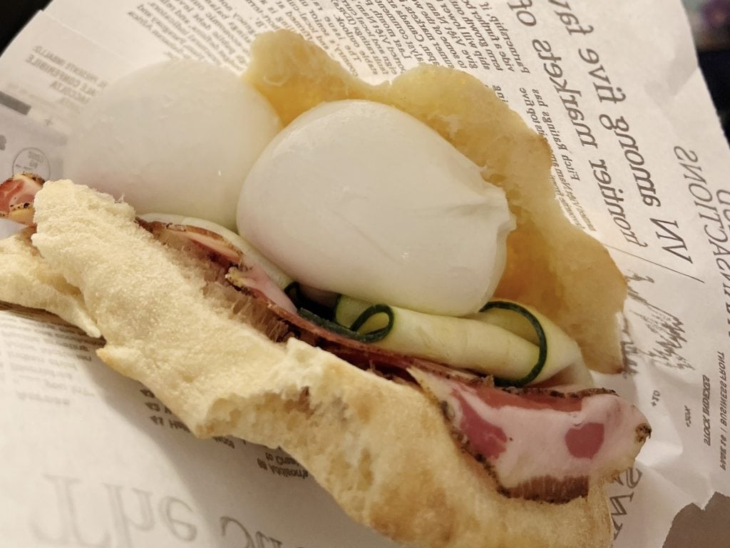 Soft-boiled eggs with ham and zucchini, served in a crispy baguette, on newspaper wrapping, perfect breakfast or brunch option from Emma Jane Explores.