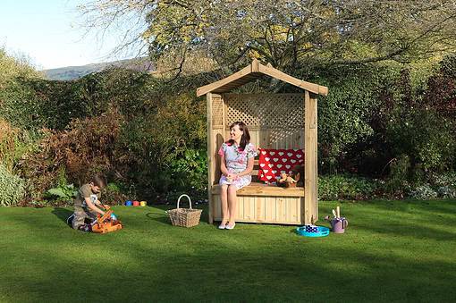 Playhouse wooden garden playhouse with kids playing and woman sitting, outdoor children’s play area, backyard garden entertainment, safe outdoor wooden playstructures for children, family garden activities.