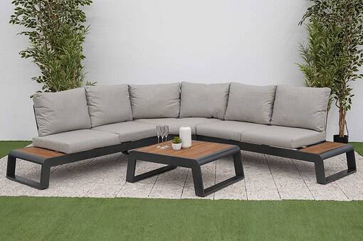 Modern outdoor sectional sofa with beige cushions and black metal frame in a stylish garden setting featuring potted plants and a coffee table.