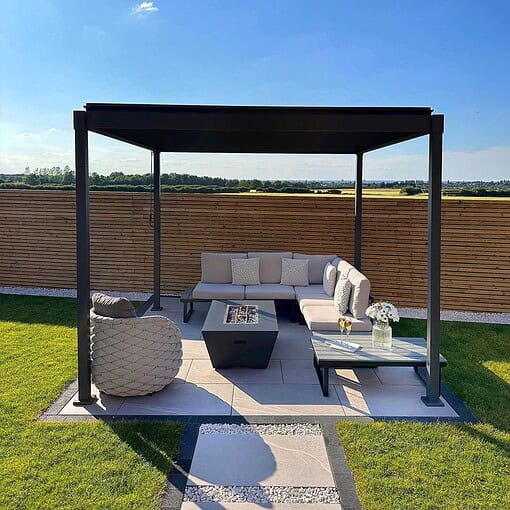 Modern outdoor lounge area with a stylish pergola, comfortable sectional sofa, and fire pit on a landscaped patio, perfect for outdoor living and garden relaxation.
