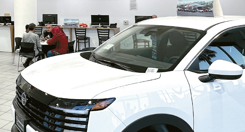 Car buyer consults with a dealer at Buena Park Auto Mall amid rising auto loan approval challenges
