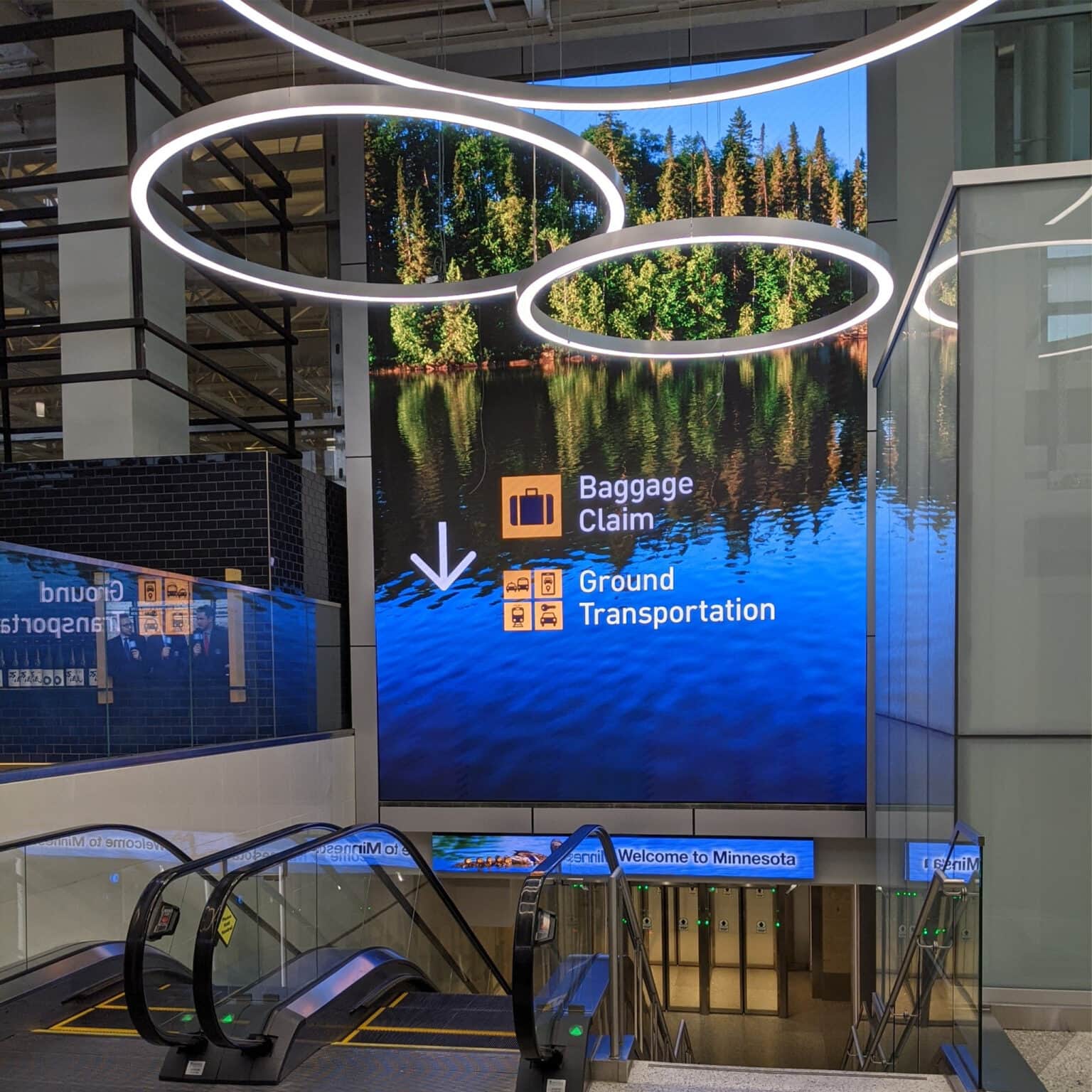 Large digital display showing a beautiful landscape and wayfinding directions.