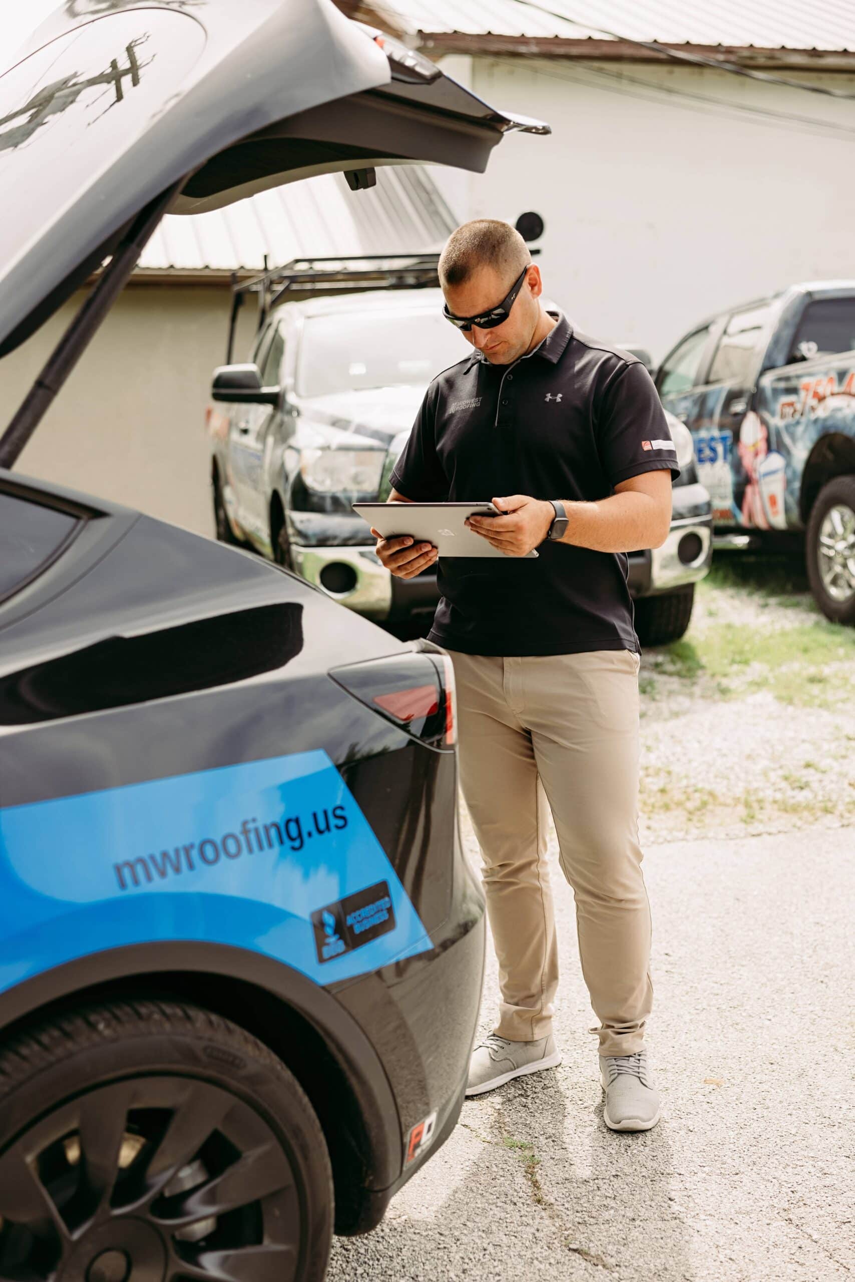 Professional roofing inspector examining a vehicle for roofing issues outdoors.