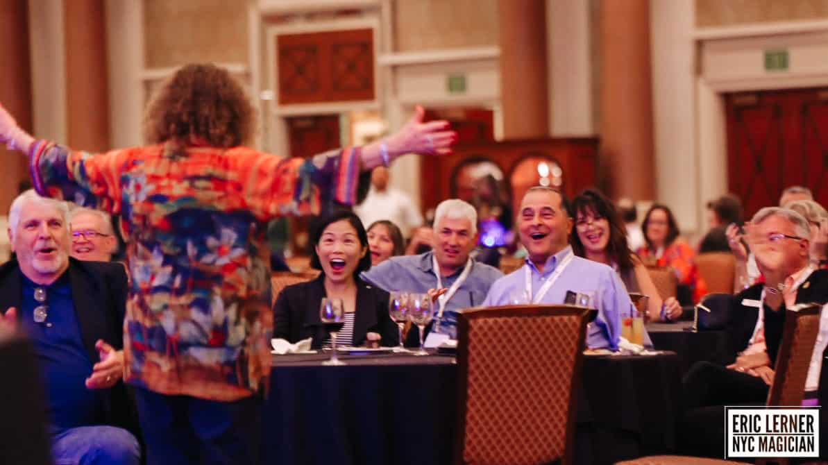 Guests fully engaged in a mind-reading performance at a company holiday party.