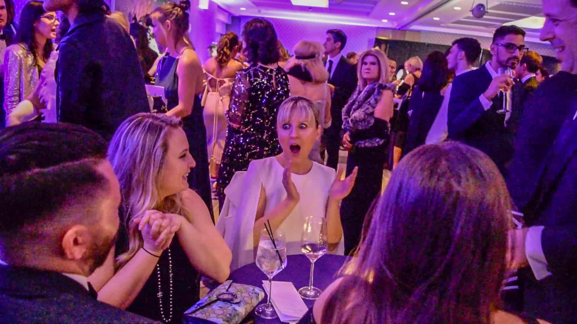 Corporate event icebreaker – guests laughing and interacting during a mind-reading performance.
