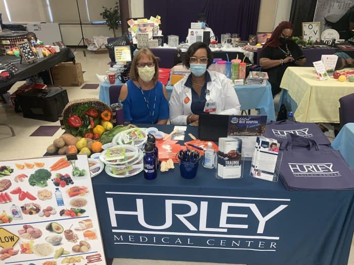 Tarnesa Martin sets up a table about nutrition at a health fair.