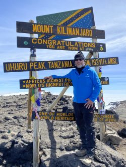 Jason Nelson stands at Uhuru Peak on Mt. Kilimanjaro