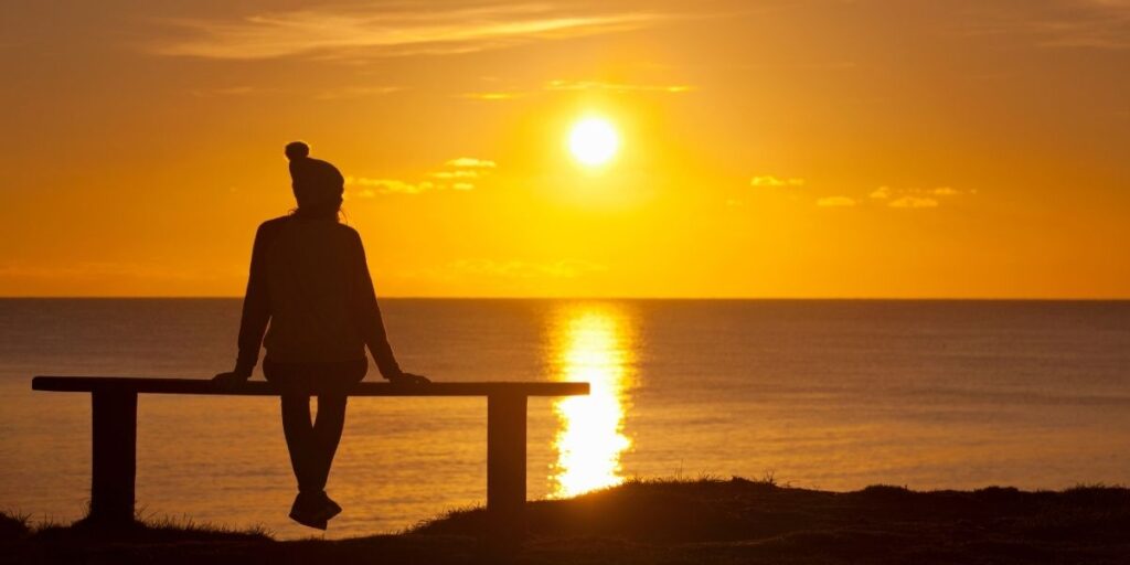 Person watching sunset over ocean